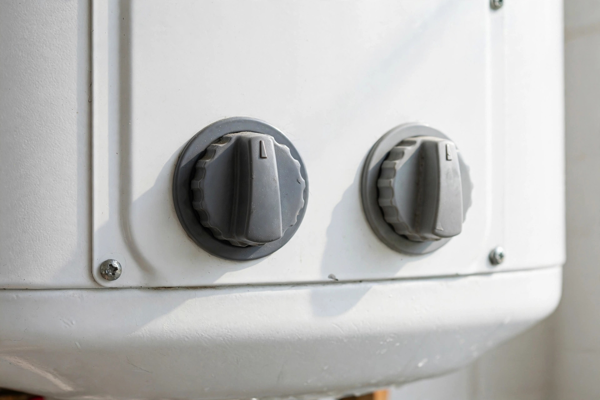 Close-up of a water heater gas control knob and temperature dial